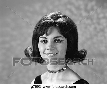 Stock Image - 1960s 1970s portrait smiling brunette woman flip hair style with bangs. Fotosearch