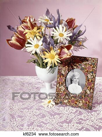 1960s 1970s spring bouquet tulips daisy white vase flowered picture frame photo of senior woman still life View Large Photo Image Picture - 1960s 1970s spring bouquet tulips daisy white vase flowered picture frame photo of senior woman still life. Fotosearch