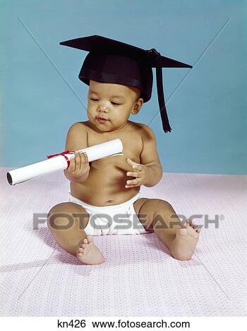 Stock Photograph - 1960s african-american baby wearing diaper graduation cap and holding diploma education. Fotosearch