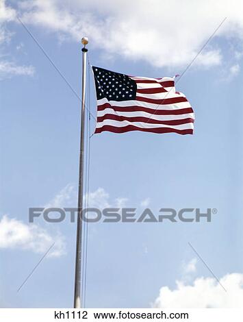 1960s american flag on pole flying against blue sky with clouds View Large Photo Image Stock Image - 1960s american flag on pole flying against blue sky with clouds. Fotosearch