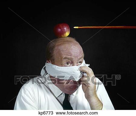 Stock Image - 1960s anxious man peeking from blindfold to arrow directed at apple top his head target william tell businessman. Fotosearch