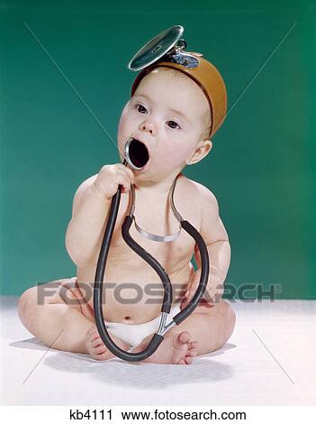 1960s baby dressed as medical doctor wearing opthalmoscope and putting stethoscope in mouth View Large Photo Image Stock Image - 1960s baby dressed as medical doctor wearing opthalmoscope and putting stethoscope in mouth. Fotosearch