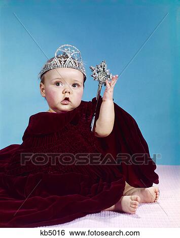 1960s baby dressed as royal queen in a velvet robe cloak cape rhinestone tiara crown and scepter wand View Large Photo Image Stock Photograph - 1960s baby dressed as royal queen in a velvet robe cloak cape rhinestone tiara crown and scepter wand. Fotosearch