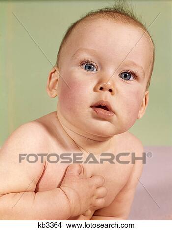 Picture - 1960s baby head portrait with sincere serious facial expression hand over heart gesture. Fotosearch