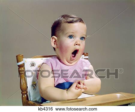 Stock Photograph - 1960s baby mouth wide open yawning singing surprised shocked amazed facial expression. Fotosearch