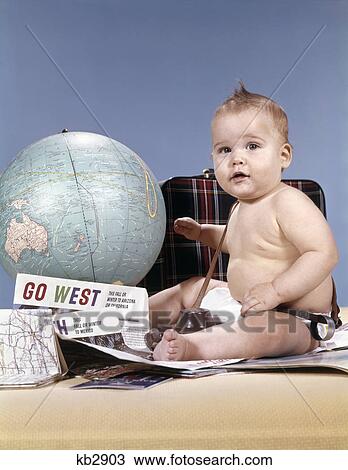 1960s baby sitting by world globe with suitcase and travel paraphernalia View Large Photo Image Stock Image - 1960s baby sitting by world globe with suitcase and travel paraphernalia. Fotosearch