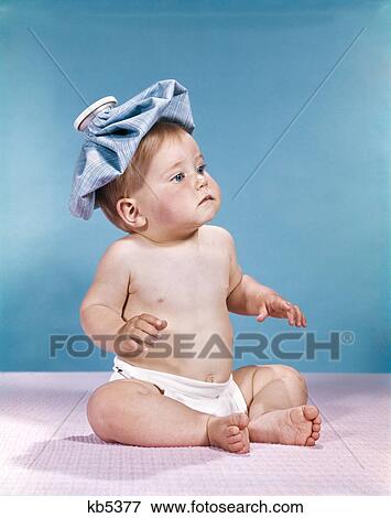 1960s baby sitting with ice pack on top of head View Large Photo Image Stock Photo - 1960s baby sitting with ice pack on top of head. Fotosearch