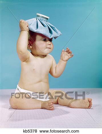 1960s baby sitting with ice pack on top of head View Large Photo Image Stock Photo - 1960s baby sitting with ice pack on top of head. Fotosearch