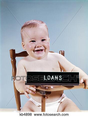 Stock Photo - 1960s baby smiling sitting high chair with banking loans sign. Fotosearch