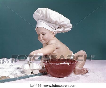 1960s baby wearing chefs hat holding egg surrounded by cooking equipment View Large Photo Image Stock Photograph - 1960s baby wearing chefs hat holding egg surrounded by cooking equipment. Fotosearch
