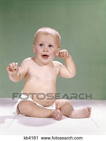 1960s baby wearing diaper sitting on pink blanket mouth open hand touching ear View Large Photo Image Stock Image - 1960s baby wearing diaper sitting on pink blanket mouth open hand touching ear. Fotosearch