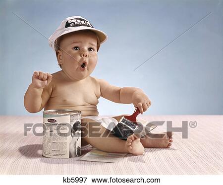 1960s baby wearing painters cap holding paintbrush with funny facial expression View Large Photo Image Stock Photo - 1960s baby wearing painters cap holding paintbrush with funny facial expression. Fotosearch