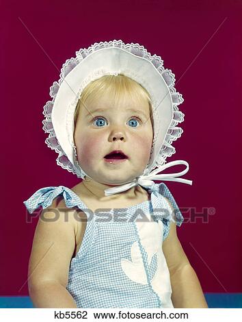 1960s blonde baby blue eyes wearing ruffled bonnet hat facial expression of wonder awe surprise View Large Photo Image Stock Image - 1960s blonde baby blue eyes wearing ruffled bonnet hat facial expression of wonder awe surprise. Fotosearch