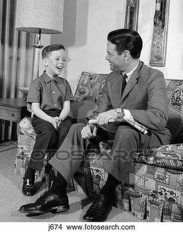 1960s boy sitting on couch smiling with dad male living room View Large Photo Image Picture - 1960s boy sitting on couch smiling with dad male living room. Fotosearch