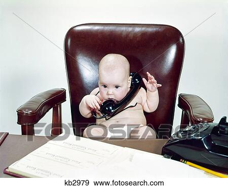 1960s chubby baby sitting leather chair at office desk holding telephone View Large Photo Image Stock Photo - 1960s chubby baby sitting leather chair at office desk holding telephone. Fotosearch