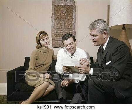 1960s couple man woman living room talking to salesman looking contract insurance View Large Photo Image Stock Image - 1960s couple man woman living room talking to salesman looking contract insurance. Fotosearch