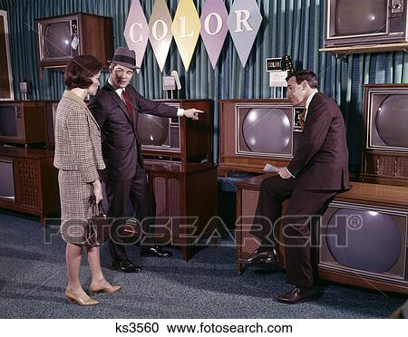 1960s couple man woman talking to salesman in color television set sales department View Large Photo Image Stock Image - 1960s couple man woman talking to salesman in color television set sales department. Fotosearch