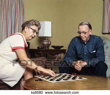 1960s elderly couple man woman playing game of checkers View Large Photo Image Stock Image - 1960s elderly couple man woman playing game of checkers. Fotosearch