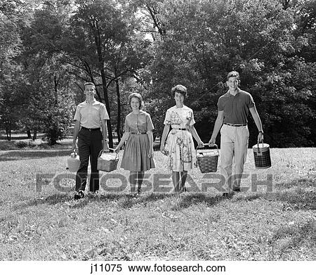 Stock Photography - 1960s family going on picnic grass trees smiling. Fotosearch