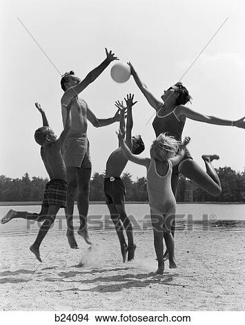 1960s family jumping playing beach volleyball View Large Photo Image Picture - 1960s family jumping playing beach volleyball. Fotosearch