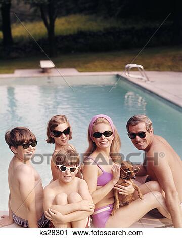 1960s funny family father mother sons daughter with dachshund dog wearing sunglasses sitting together by swimming pool View Large Photo Image Stock Image - 1960s funny family father mother sons daughter with dachshund dog wearing sunglasses sitting together by swimming pool. Fotosearch