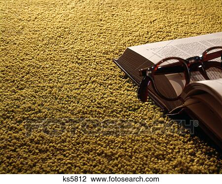 Stock Image - 1960s gold carpet open book eyeglasses. Fotosearch