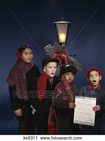 1960s group multi-ethnic boys singing christmas carols under lamp post View Large Photo Image Stock Image - 1960s group multi-ethnic boys singing christmas carols under lamp post. Fotosearch