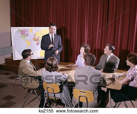 1960s group of students around table teacher standing by map View Large Photo Image Stock Photography - 1960s group of students around table teacher standing by map. Fotosearch