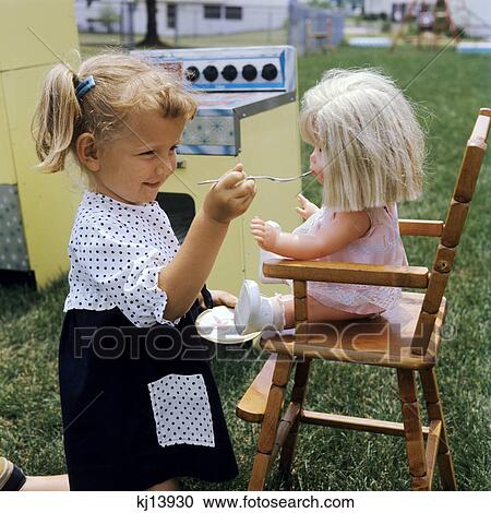 1960s little girl playing with baby doll outdoors in backyard View Large Photo Image Stock Image - 1960s little girl playing with baby doll outdoors in backyard. Fotosearch