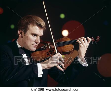 Stock Photo - 1960s man wearing tuxedo playing violin. Fotosearch