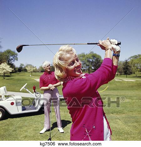1960s mature woman golfing as man stands by golf cart View Large Photo Image Stock Photograph - 1960s mature woman golfing as man stands by golf cart. Fotosearch