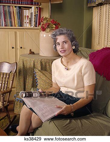 1960s middle aged woman sitting and reading magazine View Large Photo Image Stock Photo - 1960s middle aged woman sitting and reading magazine. Fotosearch