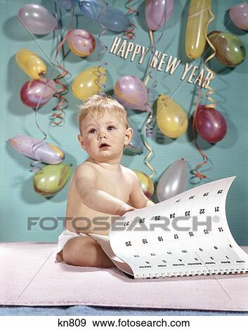Stock Photo - 1960s new year baby turning calendar page. Fotosearch