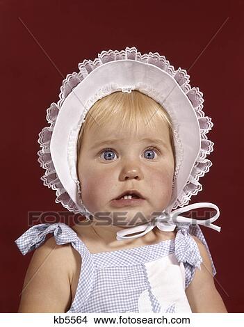 1960s portrait baby girl wearing bonnet and blue gingham dress showing two front teeth View Large Photo Image Picture - 1960s portrait baby girl wearing bonnet and blue gingham dress showing two front teeth. Fotosearch