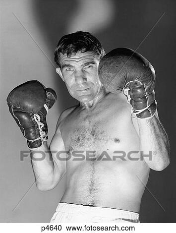 1960s portrait of boxer in dim lighting holding gloved hands up as if to block face View Large Photo Image Stock Image - 1960s portrait of boxer in dim lighting holding gloved hands up as if to block face. Fotosearch