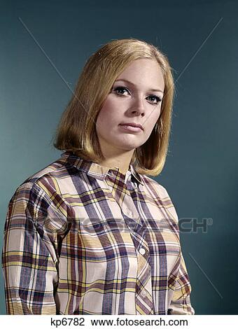 Stock Image - 1960s portrait of serious young blond woman wearing madras plaid shirt. Fotosearch