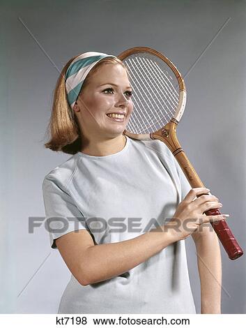 1960s portrait young blond woman hold tennis racket smiling wear blue white headband View Large Photo Image Stock Photo - 1960s portrait young blond woman hold tennis racket smiling wear blue white headband. Fotosearch