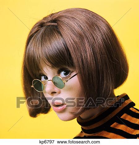 1960s portrait young brunette woman wear granny sunglasses doubtful facial expression yellow background View Large Photo Image Stock Photo - 1960s portrait young brunette woman wear granny sunglasses doubtful facial expression yellow background. Fotosearch