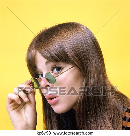 1960s portrait young brunette woman wear granny sunglasses surprised doubtful facial expression yellow background View Large Photo Image Stock Photo - 1960s portrait young brunette woman wear granny sunglasses surprised doubtful facial expression yellow background. Fotosearch