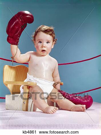 1960s prize fighter baby sitting chair wearing boxing gloves one hand raised boxer View Large Photo Image Stock Image - 1960s prize fighter baby sitting chair wearing boxing gloves one hand raised boxer. Fotosearch