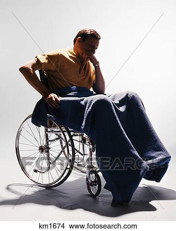 1960s sad man sitting in wheelchair blanket wrapped around legs leaning chin on hand View Large Photo Image Picture - 1960s sad man sitting in wheelchair blanket wrapped around legs leaning chin on hand. Fotosearch