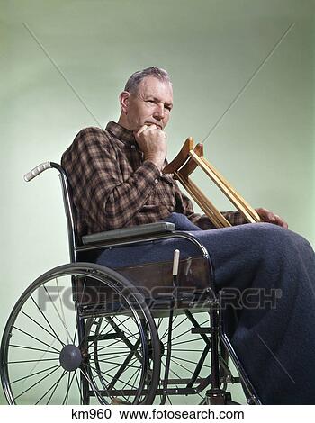1960s sad senior man sitting in wheelchair with crutches blanket wrapped around legs View Large Photo Image Stock Image - 1960s sad senior man sitting in wheelchair with crutches blanket wrapped around legs. Fotosearch