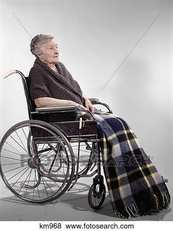 1960s sad senior woman sitting in wheelchair shawl on shoulders and a plaid lap blanket View Large Photo Image Stock Photo - 1960s sad senior woman sitting in wheelchair shawl on shoulders and a plaid lap blanket. Fotosearch