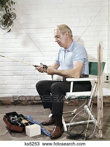 1960s senior man sitting directors chair holding fishing angling rod reel View Large Photo Image Stock Image - 1960s senior man sitting directors chair holding fishing angling rod reel. Fotosearch