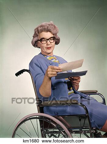 1960s senior woman wearing glasses sitting in wheelchair reading insurance check View Large Photo Image Stock Image - 1960s senior woman wearing glasses sitting in wheelchair reading insurance check. Fotosearch