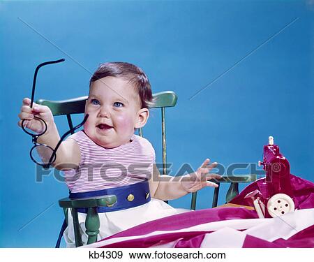 1960s smiling baby holding eyeglasses View Large Photo Image Stock Photo - 1960s smiling baby holding eyeglasses. Fotosearch