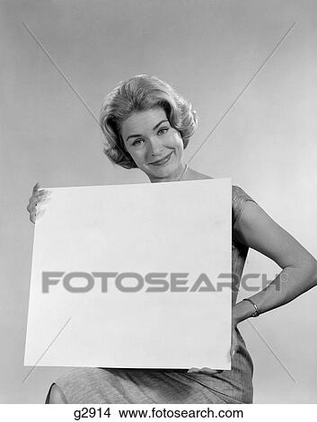 1960s smiling blond woman holding blank sign View Large Photo Image Picture - 1960s smiling blond woman holding blank sign. Fotosearch