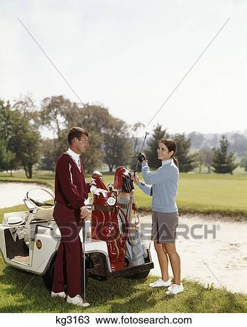1960s smiling couple man woman selecting golf clubs from golf bag on cart by sand trap View Large Photo Image Stock Image - 1960s smiling couple man woman selecting golf clubs from golf bag on cart by sand trap. Fotosearch
