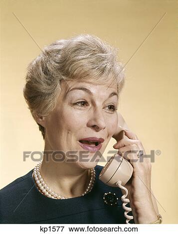 1960s smiling happy senior woman talking on telephone View Large Photo Image Stock Photo - 1960s smiling happy senior woman talking on telephone. Fotosearch