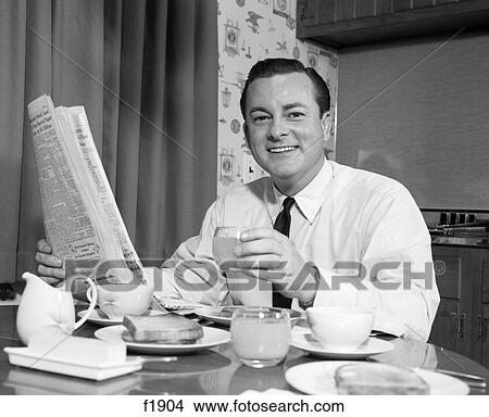 1960s smiling man eating breakfast reading newspaper View Large Photo Image Picture - 1960s smiling man eating breakfast reading newspaper . Fotosearch